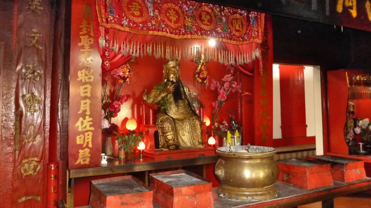 Roter Schrein mit goldener Buddhafigur.