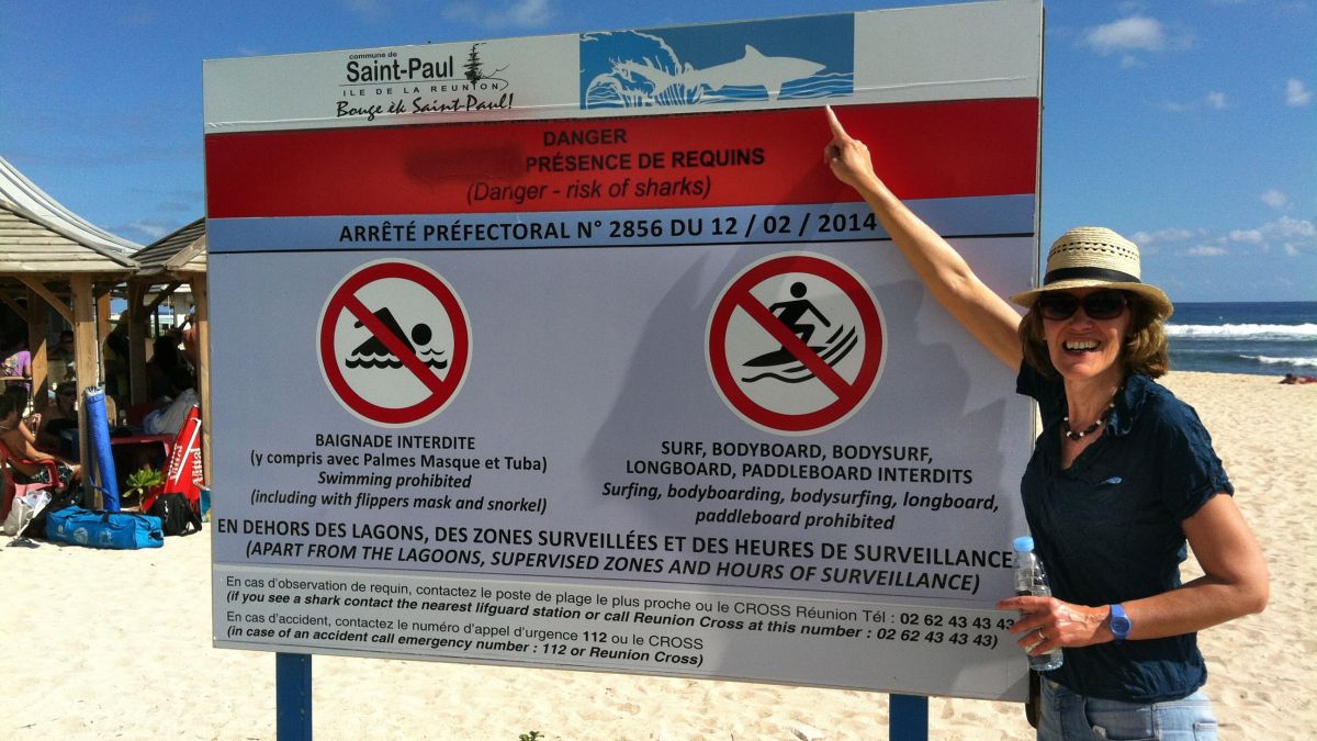 Warnschild am Strand, das vor Haien warnt.