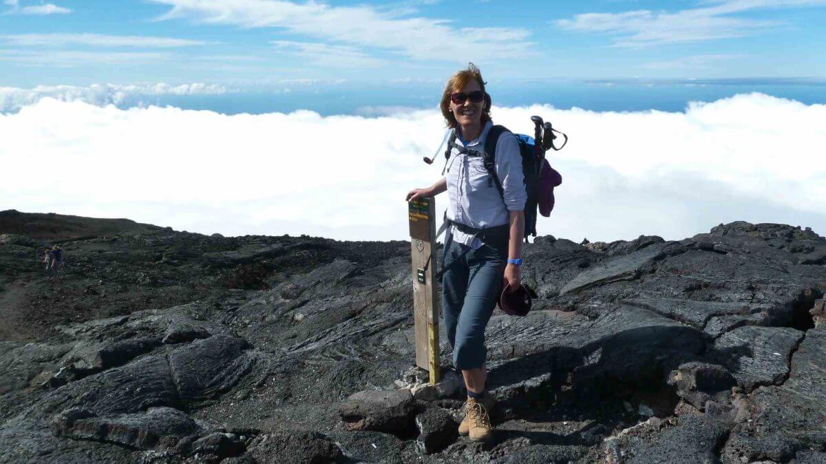 Gina steht am Wegweiser zum Gipfel des Piton de la Fournaise.