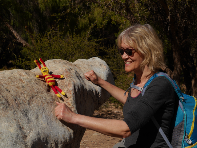 Gina klopft auf einen großen Felsen.