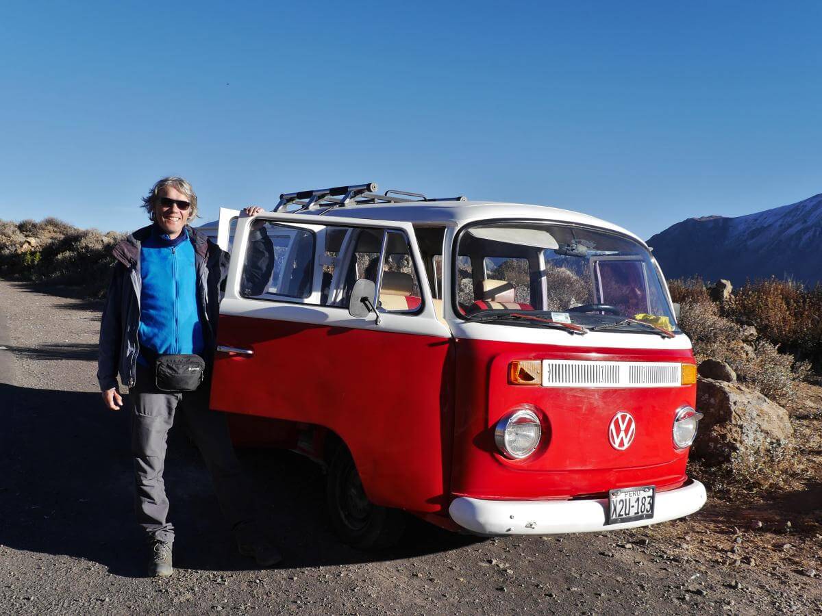 Marcus steht neben einem rot-weißen VW-Bulli.