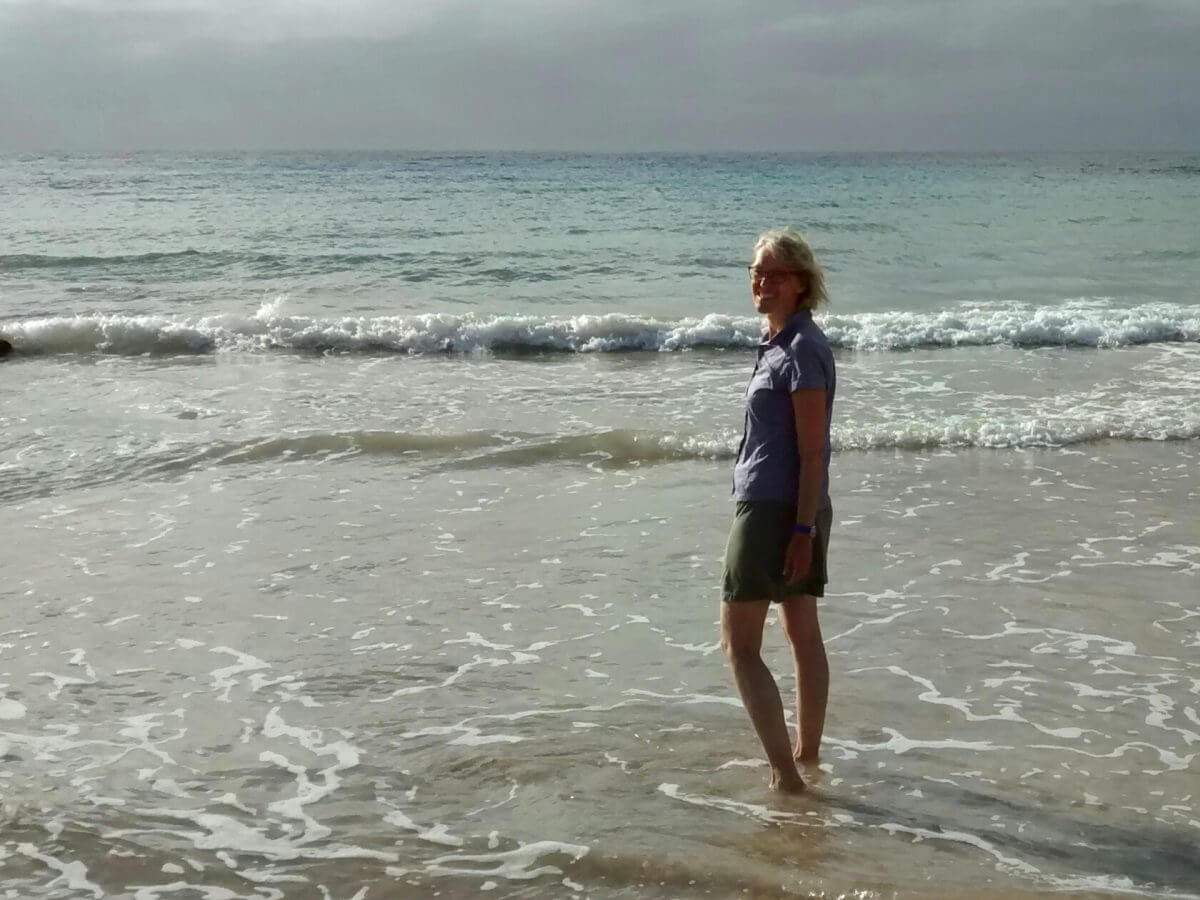 Gina steht im flachen Wasser des Anakena Strandes der Osterinsel.