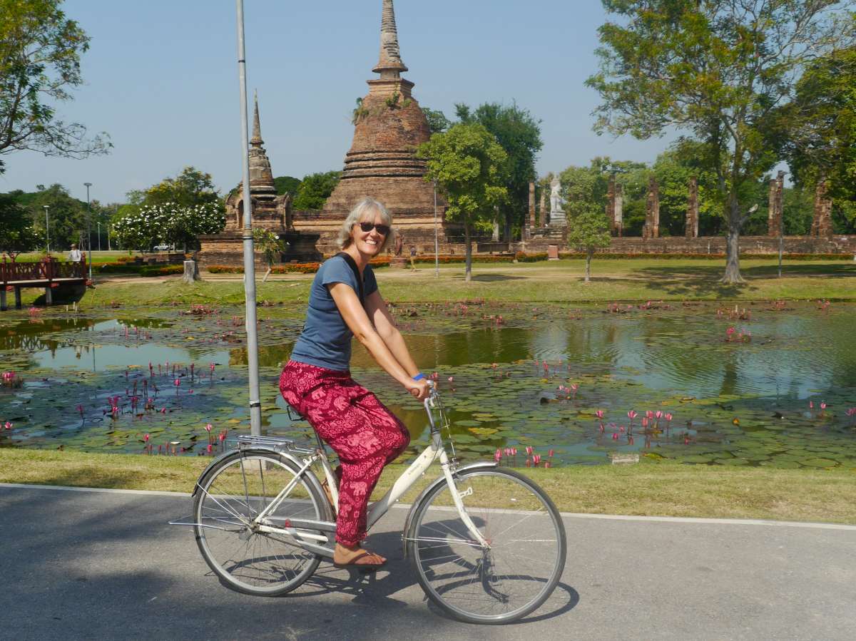 Gina radelt vor einem Chedi entlang.