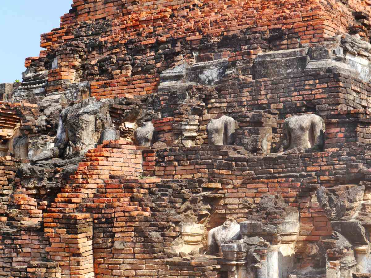 Viele zerborstene Buddha-Statuen entlang des Tempels.