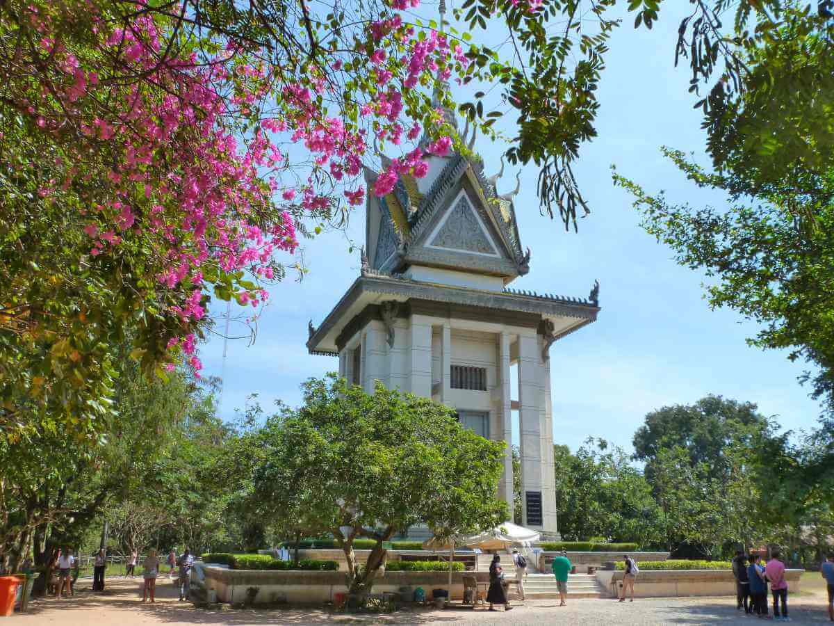 Weißer Stupa, umgeben von blühenden Sträuchern auf den Killing Fields.