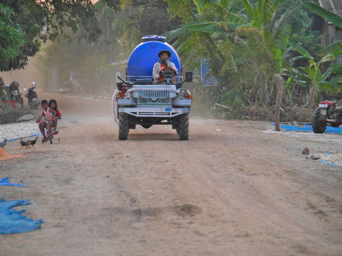 Fahrzeug auf staubiger Dorfstraße in Banteay Chhmar.