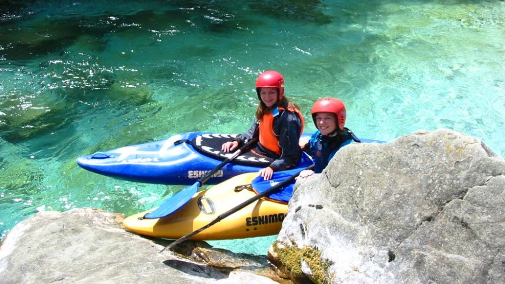 Zwei Kajak-Paddler auf dem türkisen Wasser der Soca.