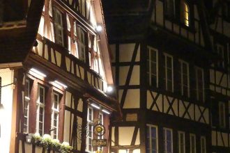 beleuchtete Fachwerkhäuser bei Nacht in Straßburg im Winter