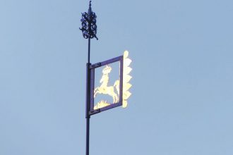 goldene Dachfahne vor blauem Himmel