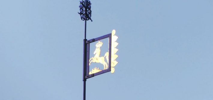 goldene Dachfahne vor blauem Himmel