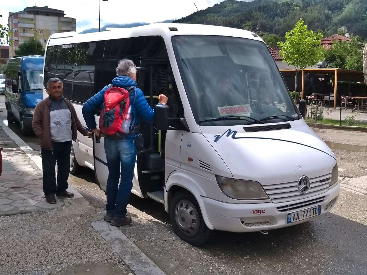 Marcus steht vor einem weißen Kleinbus und spricht mit dem Fahrer.