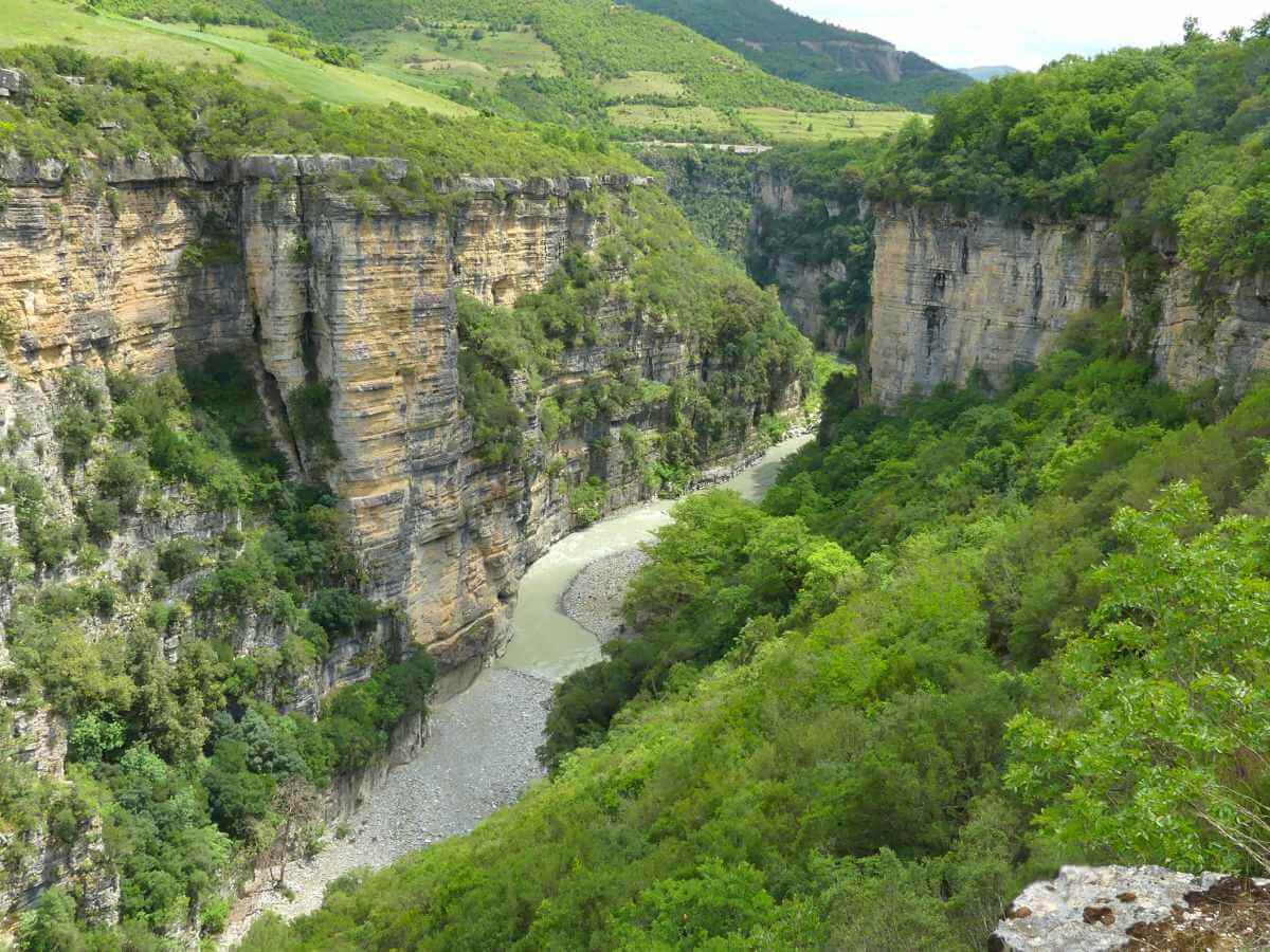 Canyon mit steilen Felswänden und einem Fluss am Grund.