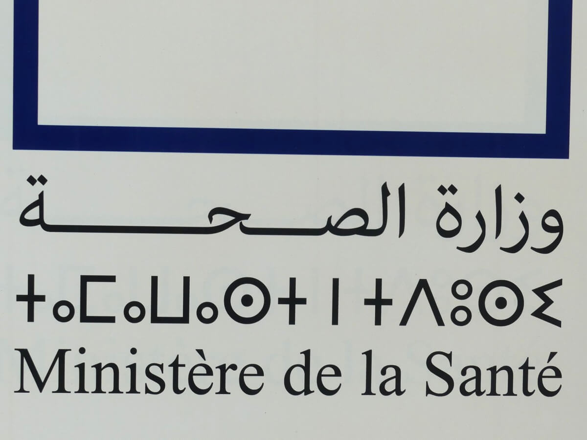 Schild mit dreisprachiger Beschilderung.