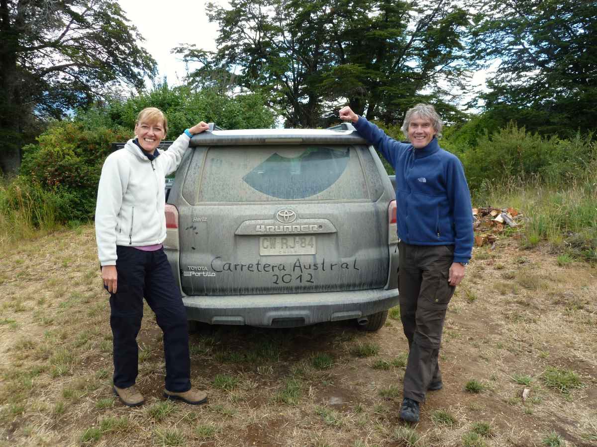 Gina und Marcus stehen am staubbedeckten Geländewagen.