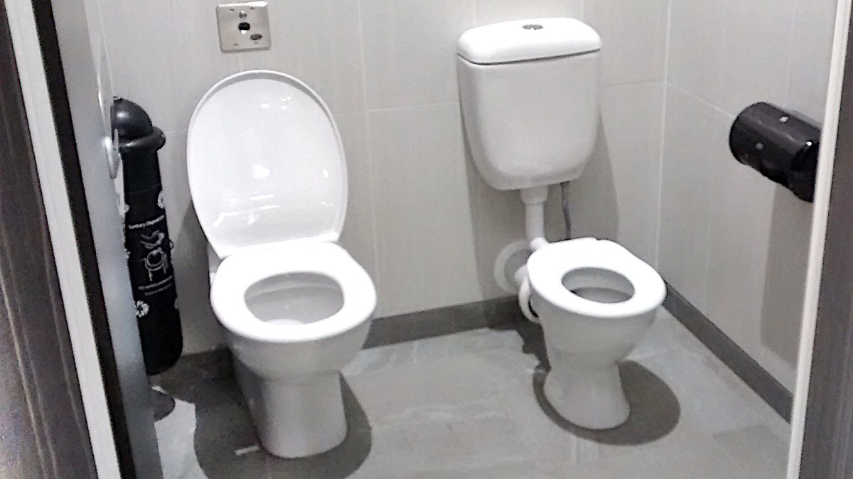 2 Toiletten in einer Kabine.