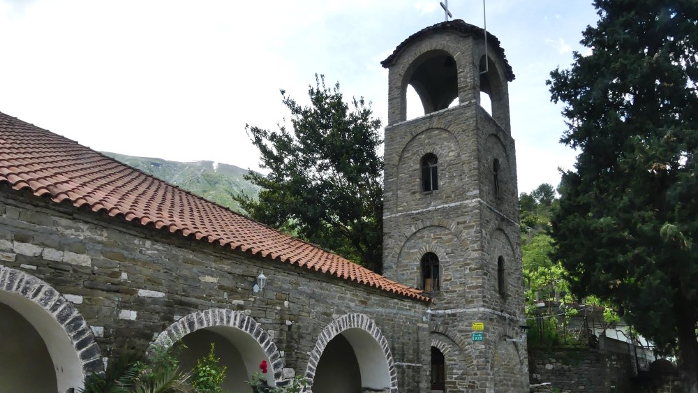 Orthodoxe Kirche mit Turm und Steinbögen.