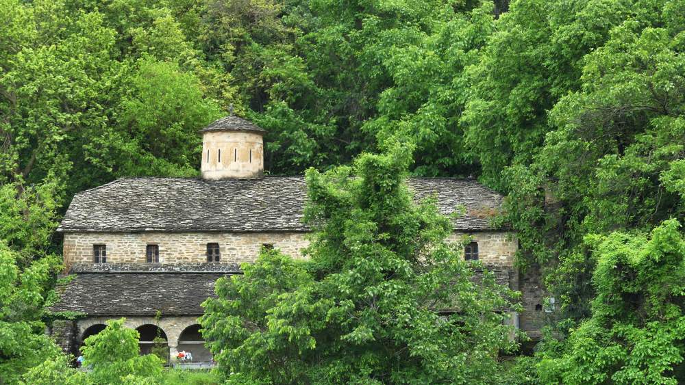 Kirche ragt aus dem Wald hervor.