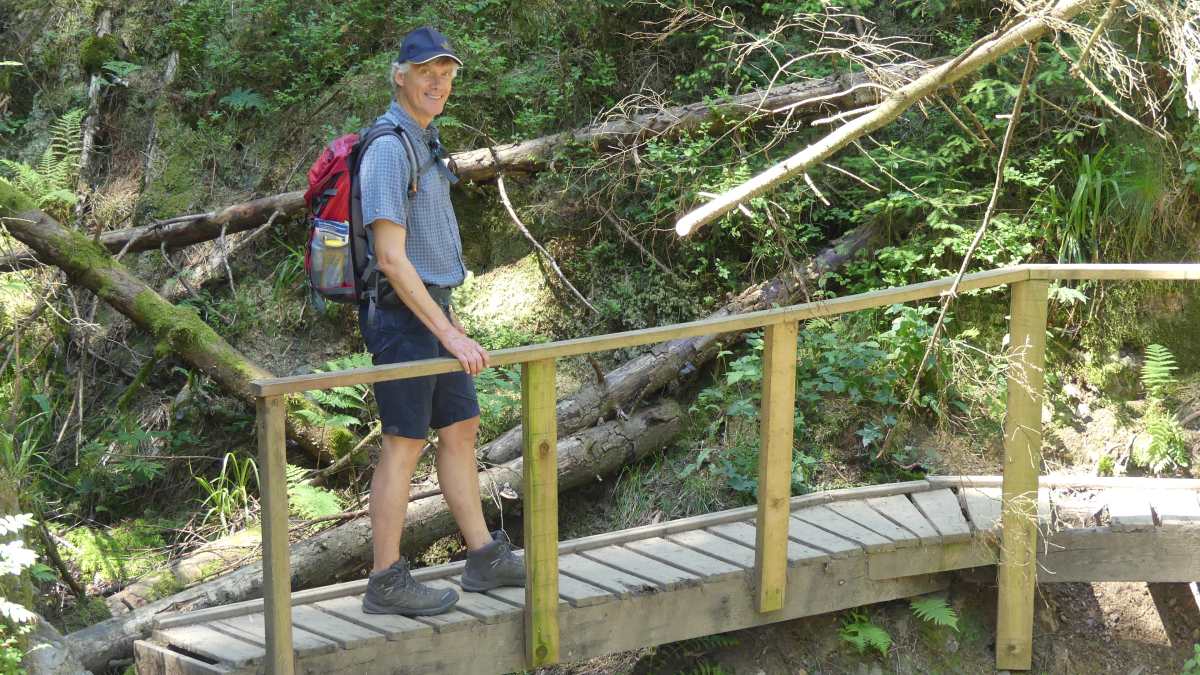 Marcus auf einem Holzsteg im Wald.