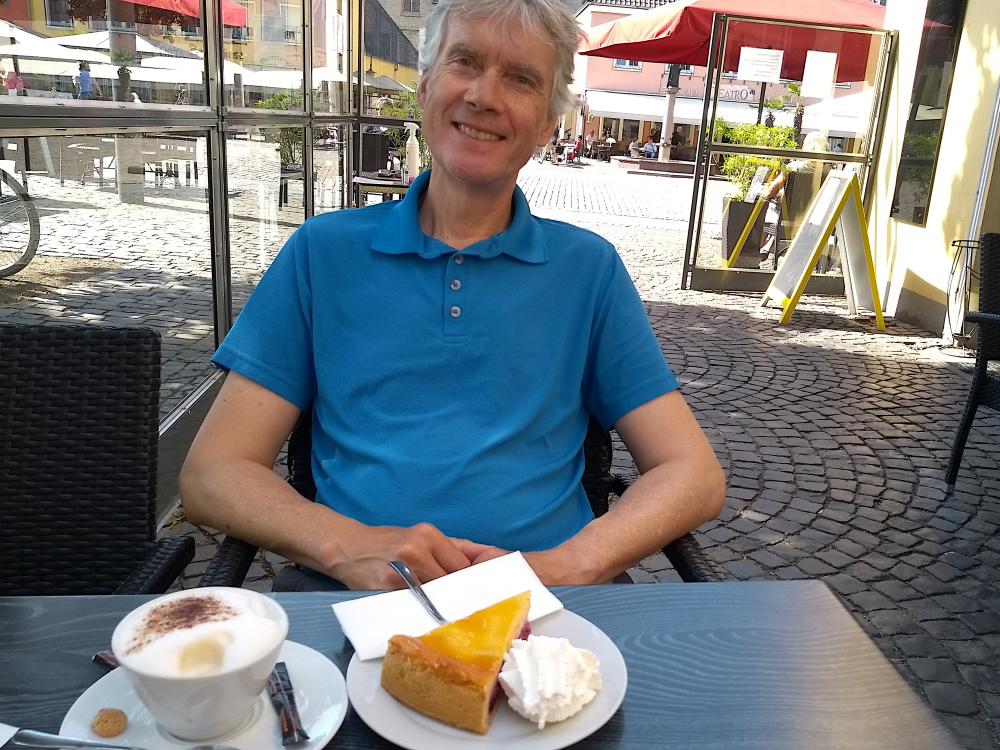 Marcus vor Kaffee und Kuchen am Tisch.