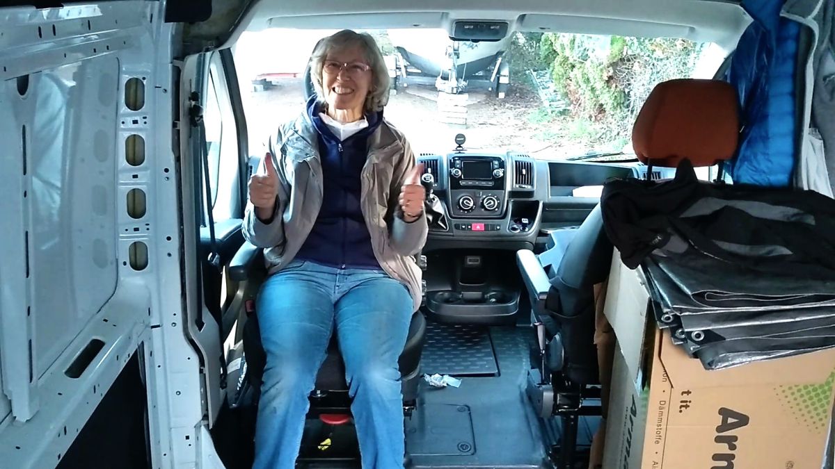 Gina sitzt auf dem nach hinten gedrehten Fahrersitz.