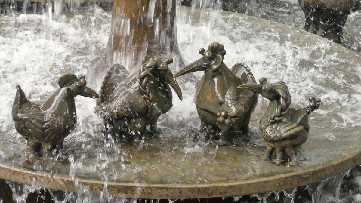 Fantasievögel in sprudelndem Brunnen.