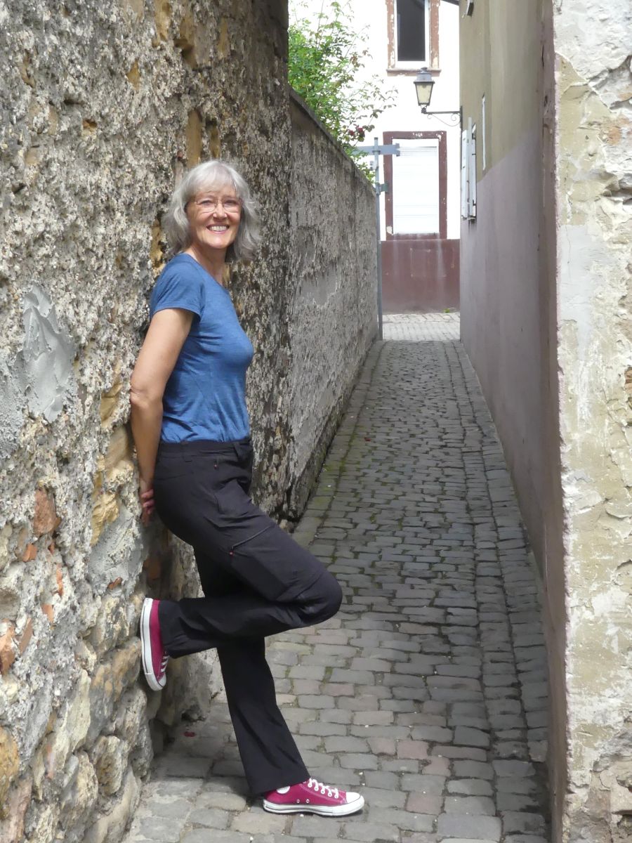 Gina lehnt an der Stadtmauer.