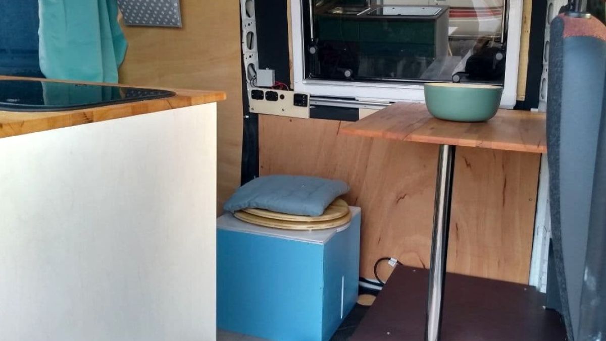 Trockentrenntoilette als Sitzgelegenheit am Tisch.