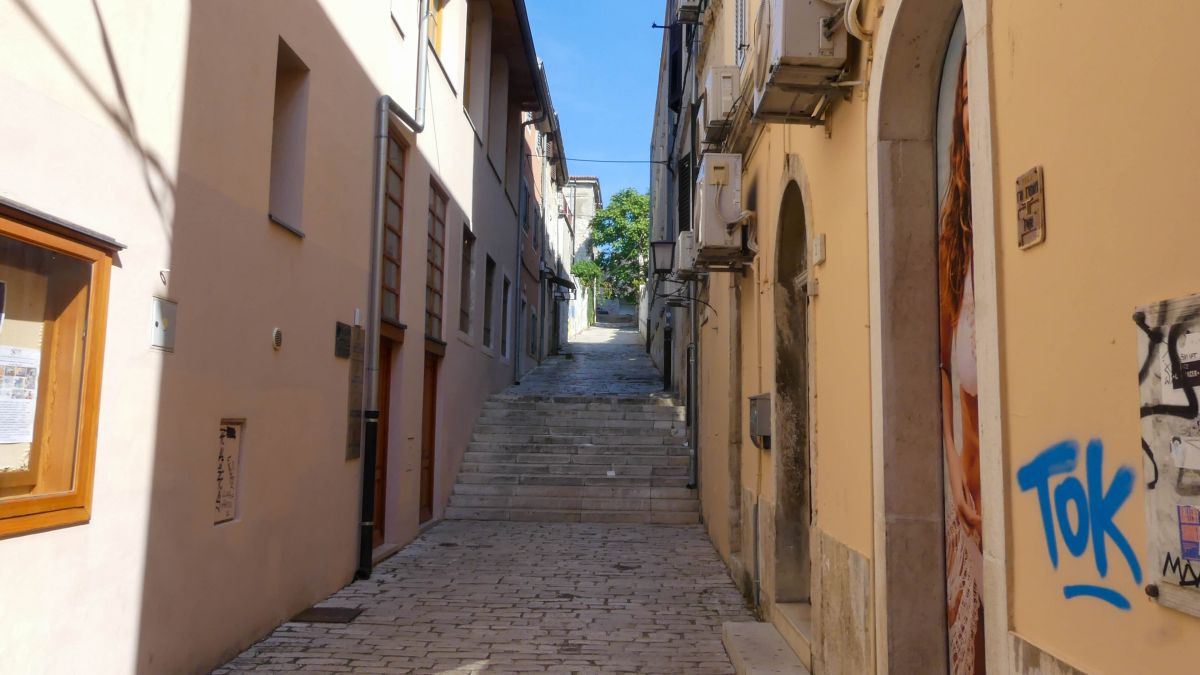 Schmale Gasse mit Kopfsteinpflaster.