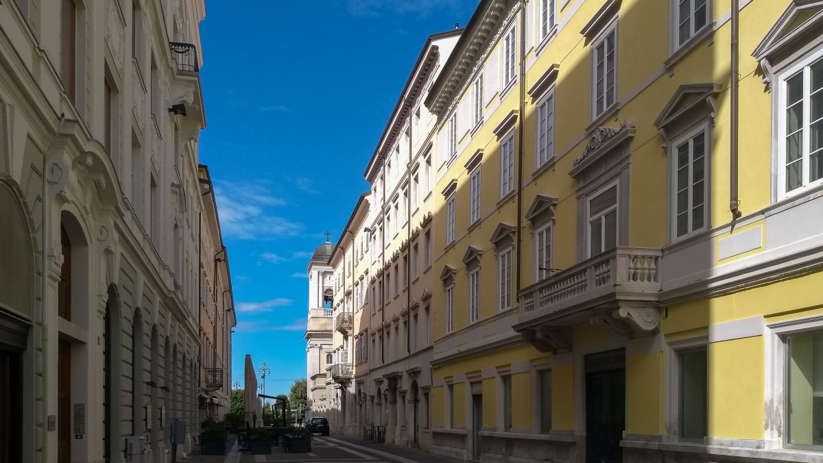 Mehrstöckige Häuser mit hellen Fassaden säumen die Straße.