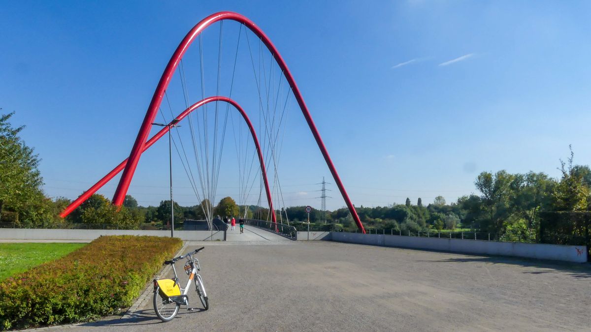 Brücke mit hohen roten Stahlbögen.