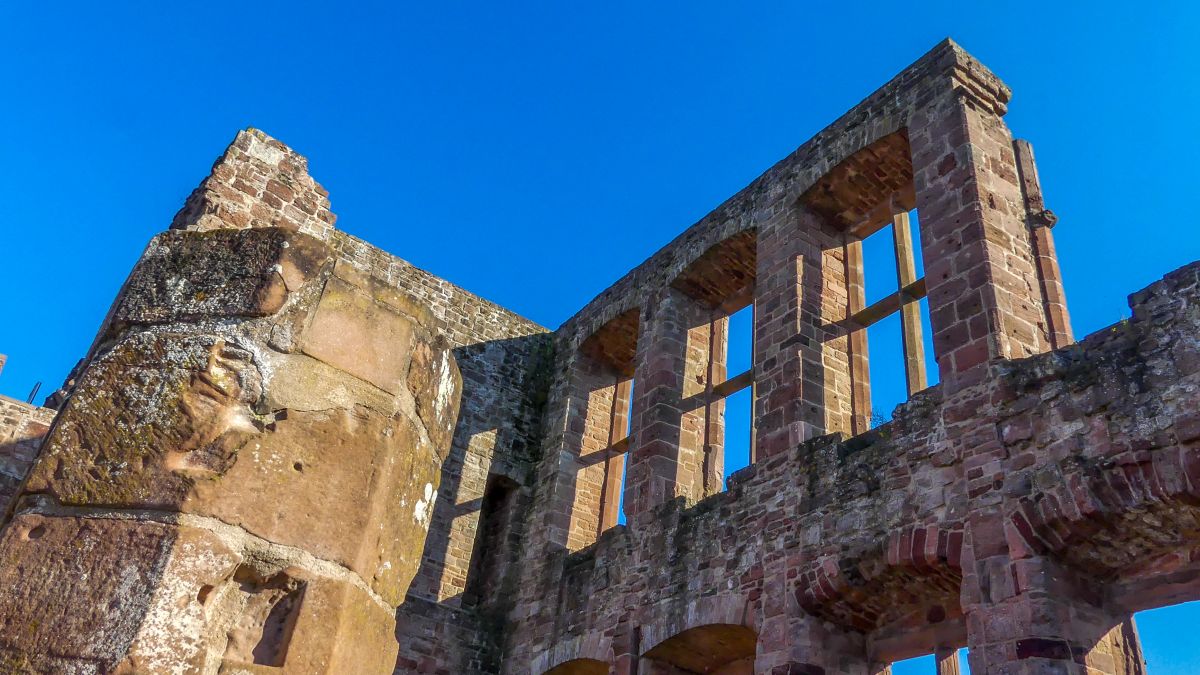 Burgruine vor blauem Himmel.