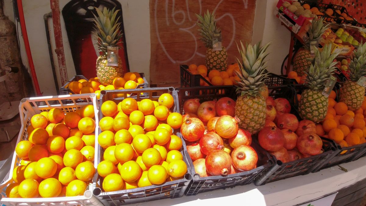 Marktstand mit Orangen und Granatäpfeln.