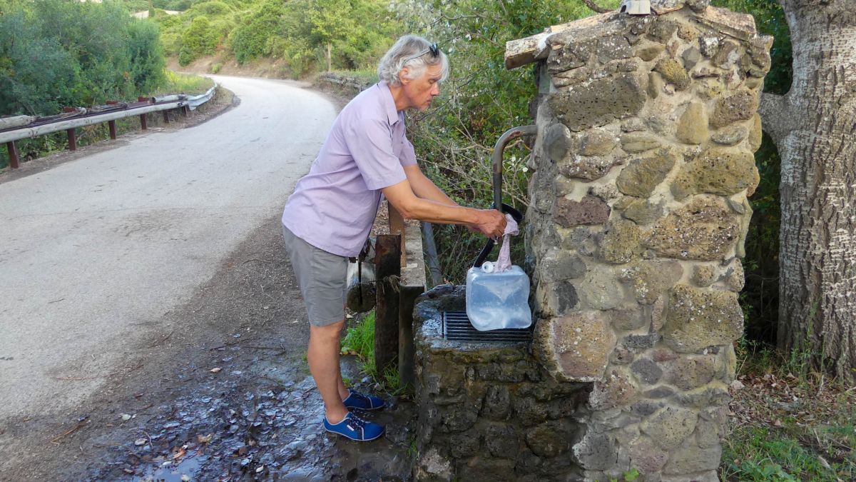 Marcus füllt einen Wasserkanister an der Quelle.