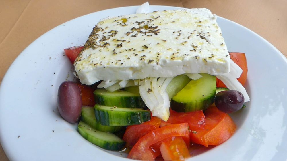 Griechischer Salat mit einer Scheibe Feta oben drauf.