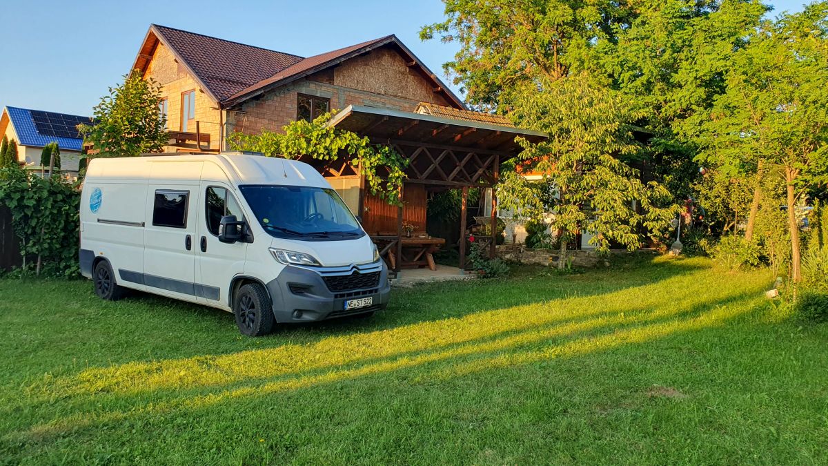 Wohnmobil steht im Garten.