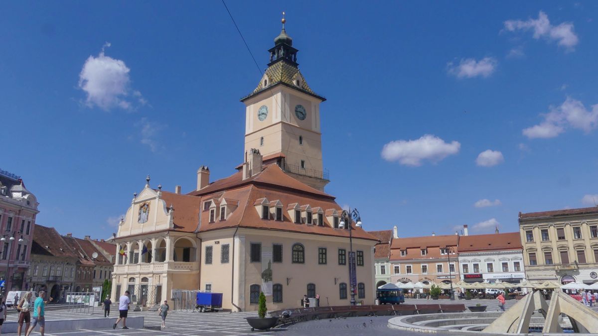 Platz mit Rathaus, das von einem großen Turm gekrönt wird.