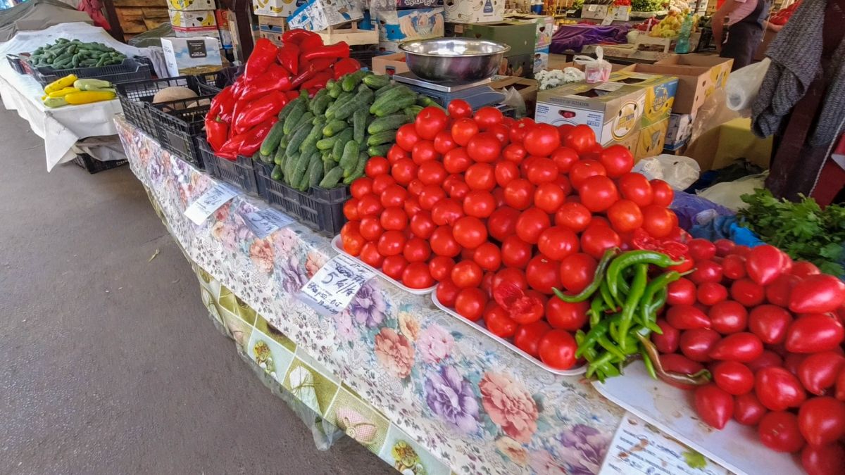 Marktstand mit Tomaten, Paprika und Zucchini.