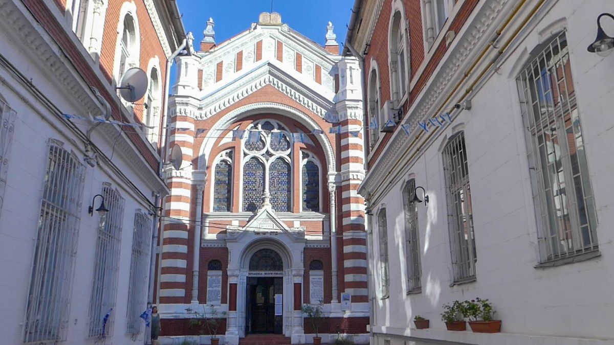 Synagoge am Ende der Gasse, mit rot-weißem Mauerwerk.