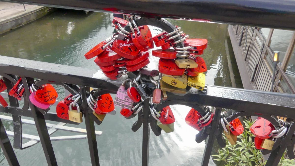 Knallrote Schlösser in Herzform am Geländer der Brücke.