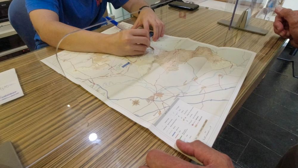 Mitarbeiterin skizziert die Route auf einer Karte der Bardenas Reales.