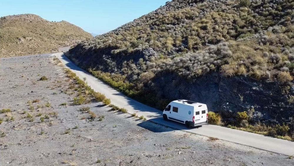 Wohnmobil fährt auf einer schmalen Straße in Spanien.