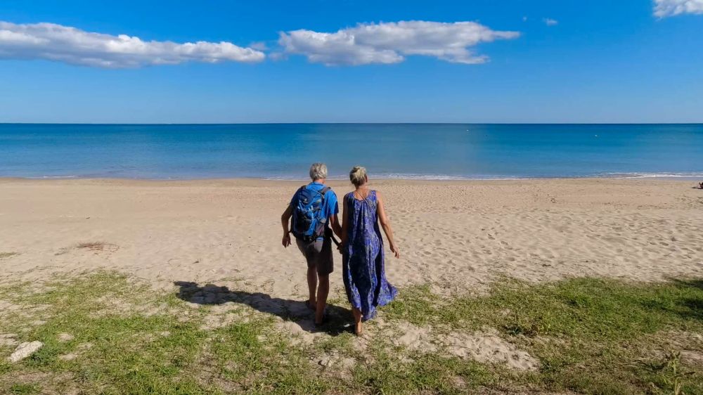 Gina und Marcus laufen den Strand hinunter auf das Meer zu.