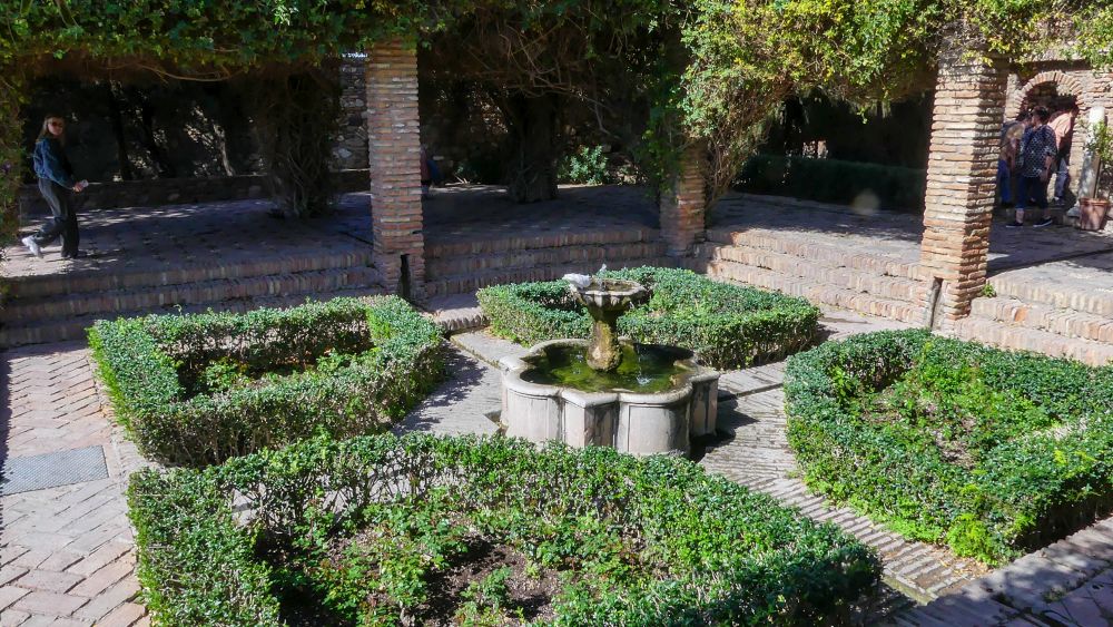 Garten mit vier quadratischen Beeten.