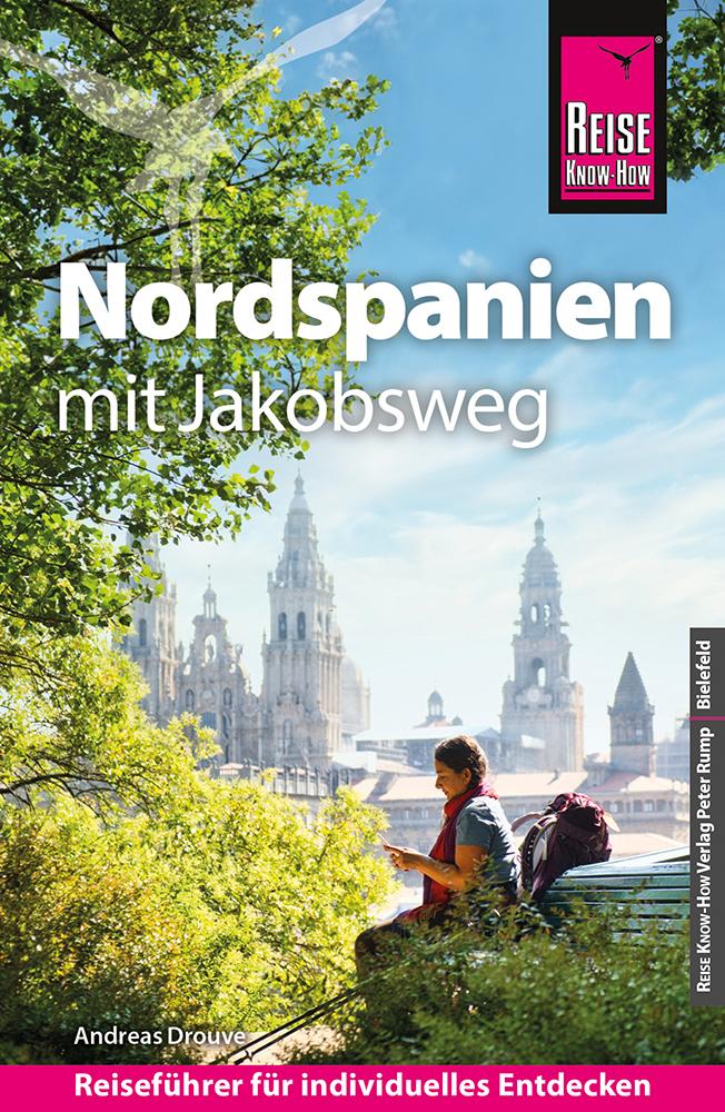 Titelbild eines deutschen Reiseführers, auf dem Menschen auf einer Bank sitzen und den Blick auf die Türme einer Kathedrale in Nordspanien genießen; der Titel lautet „Nordspanien mit Jakobsweg“.