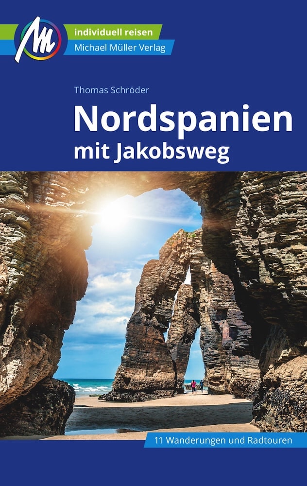 Buchcover mit der Abbildung einer Felsbogenformation an einem felsigen Strand unter blauem Himmel, mit dem Titel „Nordspanien mit Jakobsweg“ und dem Untertitel „11 Wanderungen und Radtouren“ auf Deutsch.