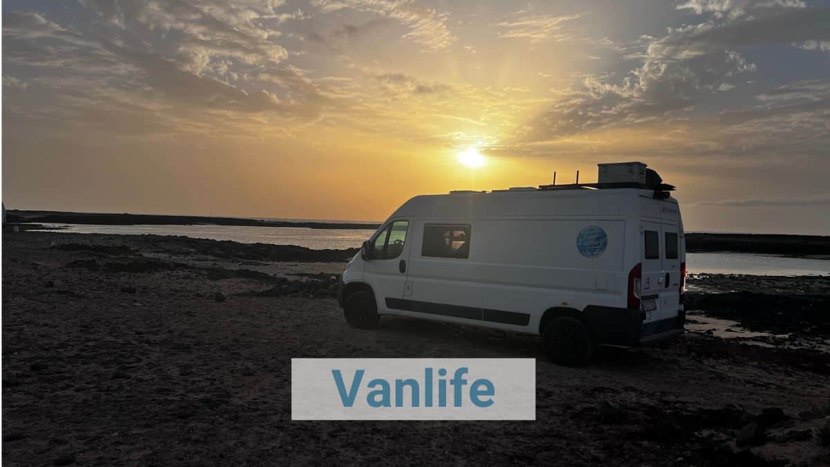 Zwei Vans stehen auf einem Parkplatz am Meer.